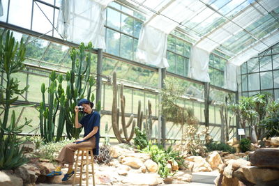 Man sitting in greenhouse