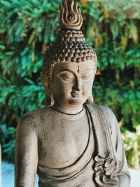 Close-up of buddha statue against plants