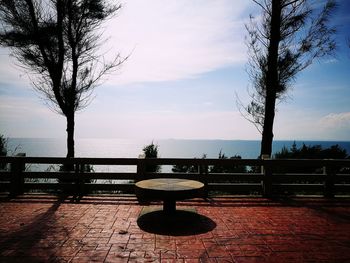 View of empty bench against calm sea