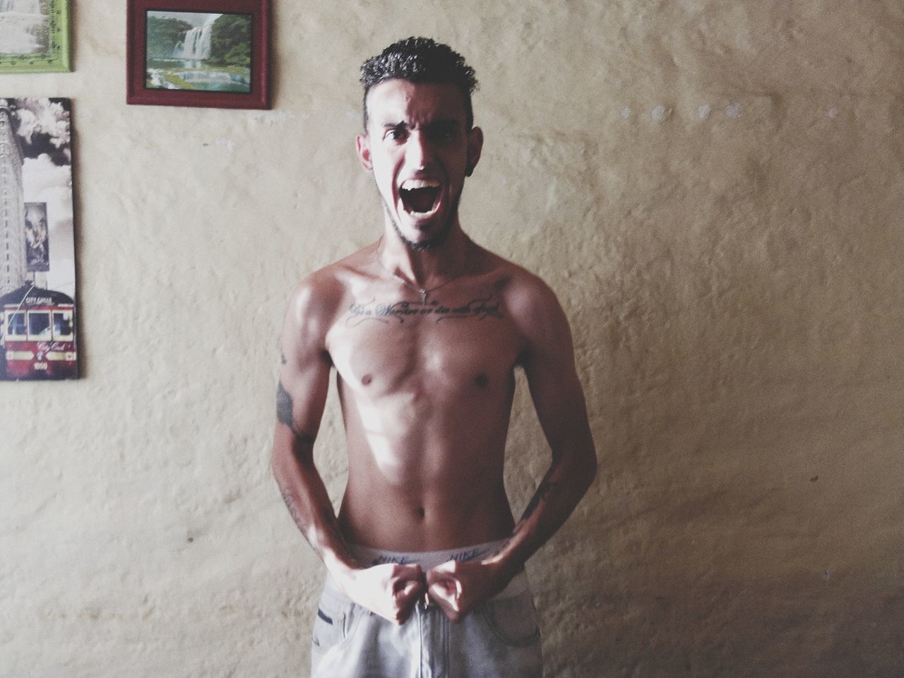 shirtless, one person, standing, young adult, young men, lifestyles, real people, indoors, wall - building feature, three quarter length, front view, leisure activity, portrait, emotion, looking at camera, muscular build, men, strength, chest, teenage boys