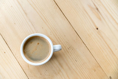 High angle view of coffee cup on wooden table