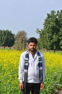 Young indian farmer at black mustard field