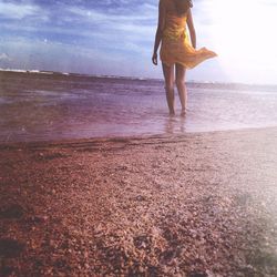 Low section of woman standing on beach