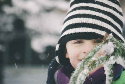 Close-up portrait of smiling boy by frozen plants