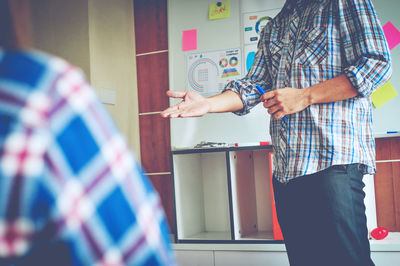 Midsection of businessman explaining to colleague in office