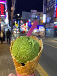 Close-up of ice cream on illuminated street at night