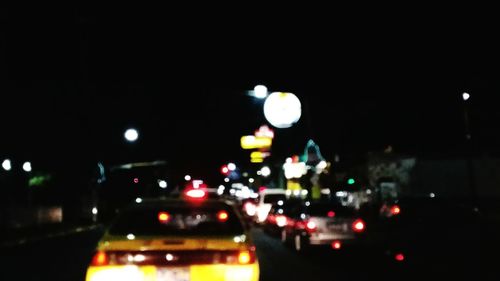 Close-up of illuminated cars on road in city at night