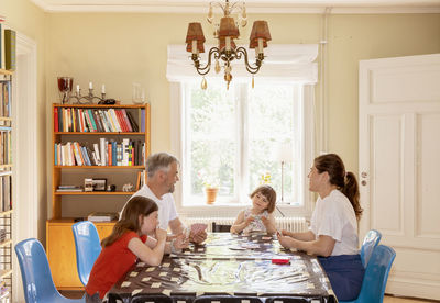 Family playing cards at table