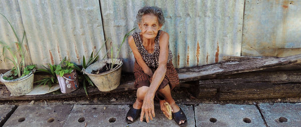 Portrait of girl sitting on wood