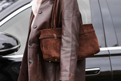 Midsection of woman standing in car