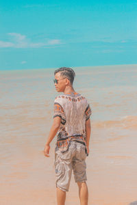 Rear view of man standing on beach