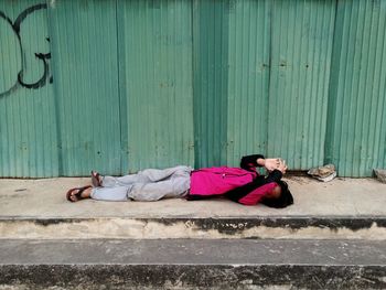 Full length of man lying on footpath