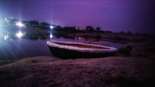 Boat moored on lake against sky at night