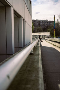 Road by building in city against sky