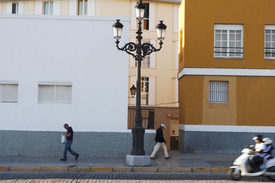 People walking on street against building in city