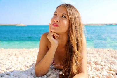Smiling young woman lying at beach