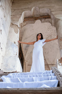 Full length of woman standing against white wall