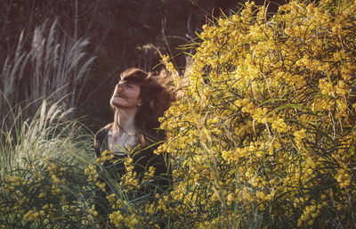 Woman with tousled hair amidst plants