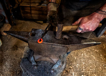 Midsection of man working on metal