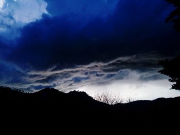 Low angle view of silhouette mountain against dramatic sky