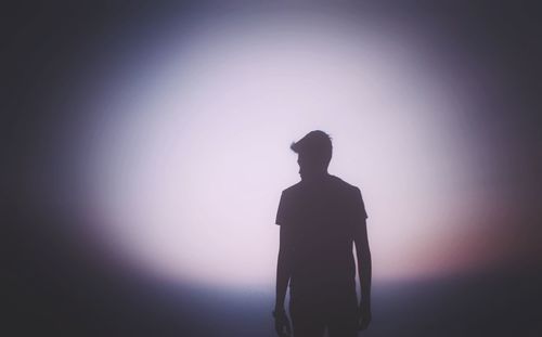 Rear view of silhouette man standing against clear sky