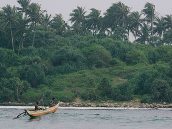 People in boat against trees