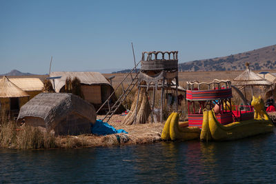 Panoramic view of houses by lake against sky