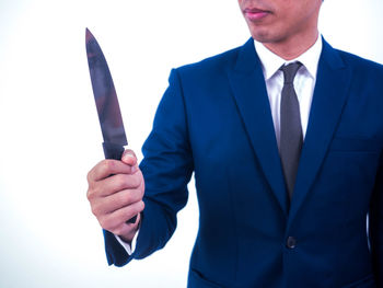 Midsection of man holding hands against white background
