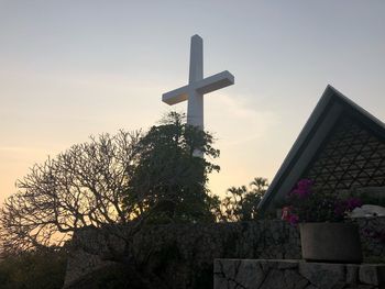 Low angle view of cross on building against sky