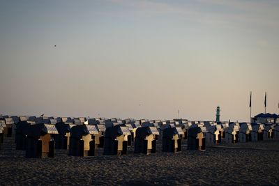 Row of hooded beach chairs against clear sky