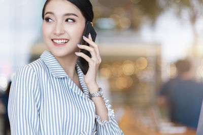 Portrait of young woman using mobile phone