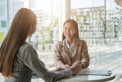 Smiling business colleagues discussing in office