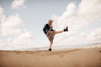 Full length of woman standing on beach against sky