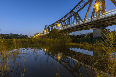 Bridge over river against sky at night