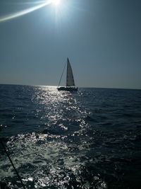 Sailboat sailing on sea against clear sky