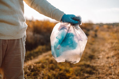 Midsection of man holding plastic