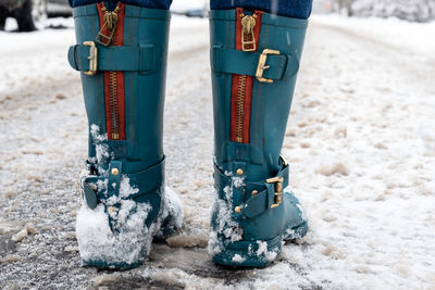 Snowy and slippery roads. woman in rubber boots