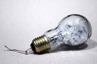 Close-up of light bulb against white background