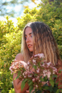 Portrait of young blonde woman with mermaid waves in her hair connecting her spirit with wild nature