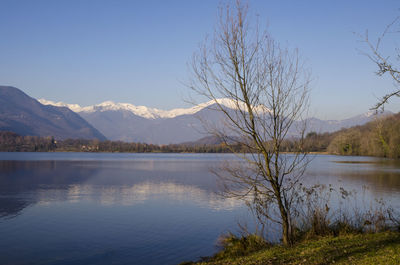 Scenic view of lake by mountains against sky