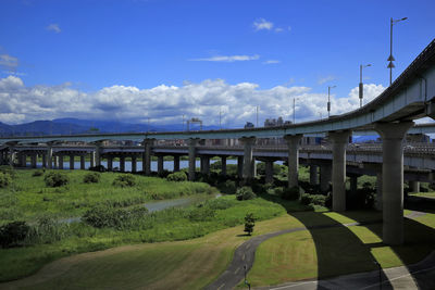 Bridge over road in city against sky