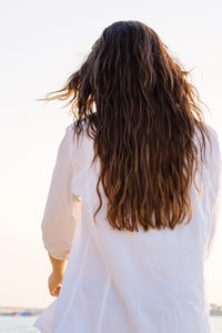 Rear view of woman standing against clear sky