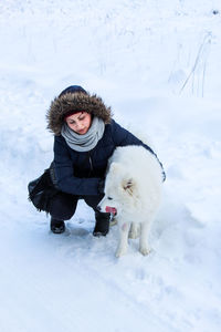 Full length of woman with dog on snow field