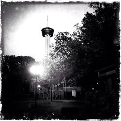 Illuminated street light against sky at night