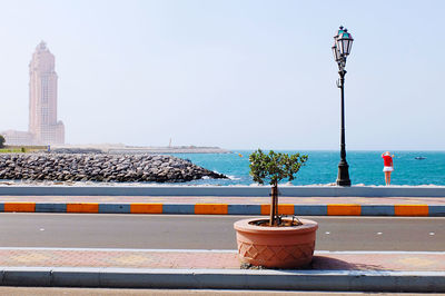 Street light by sea against clear sky