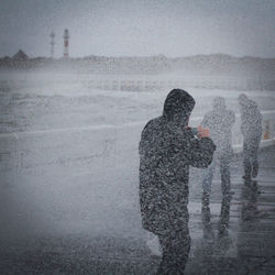 Shadow of woman photographing on sea during winter