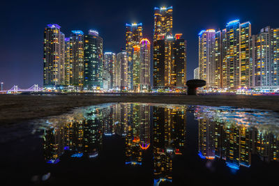 Illuminated buildings in city against sky at night