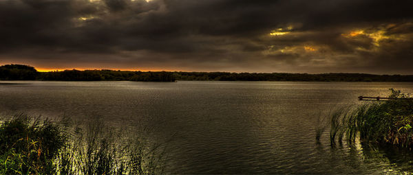 Scenic view of lake against cloudy sky