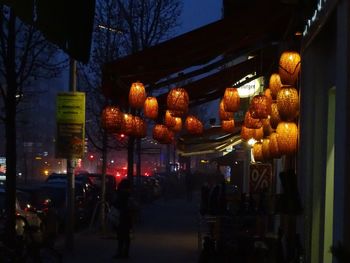 Illuminated christmas lights hanging in city at night