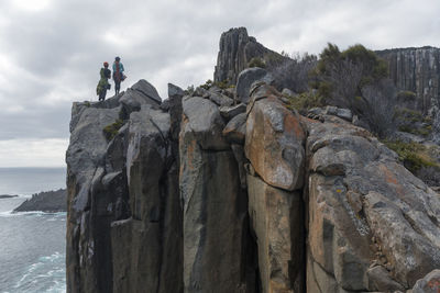 Rock formations by sea against sky